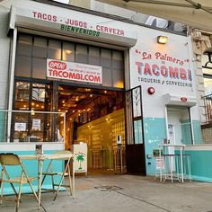 the outside of a taco shop with tables and chairs