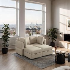 a living room filled with lots of furniture and large windows overlooking the cityscape