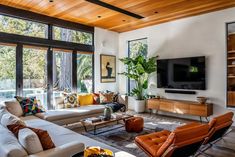 a living room filled with furniture and a flat screen tv mounted on a wall above a fireplace