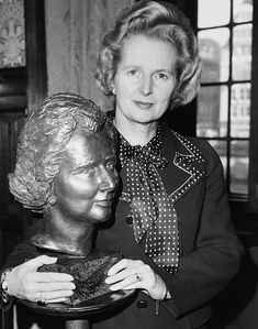 an old photo of a woman holding a statue