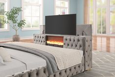 a bedroom with a bed, tv and fireplace in it