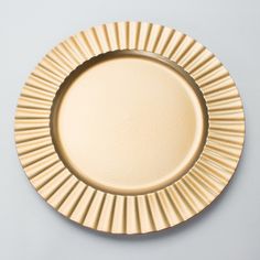 an empty gold plate on a white surface with no one around it or someone else