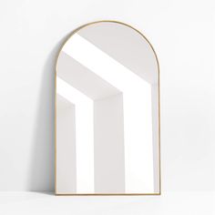 an arch shaped mirror is shown against a white wall