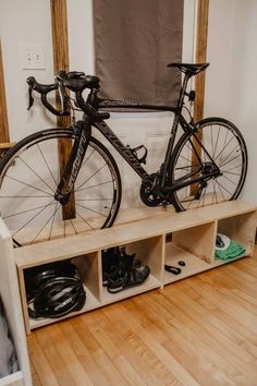 there is a bike that is sitting on a shelf in the room next to some shoes