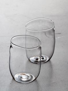 two empty wine glasses sitting next to each other on top of a white countertop