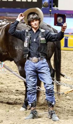 a man standing next to a brown horse