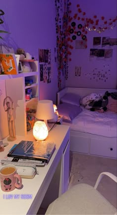 a room with a bed, desk and chair in the corner is lit up by purple lighting