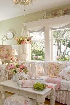 a living room filled with lots of furniture and flowers on the couches in front of a window