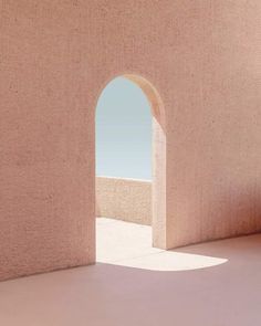 an arch in the side of a pink wall