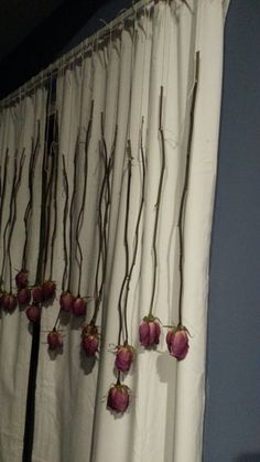 flowers are hanging on the curtain in front of a window