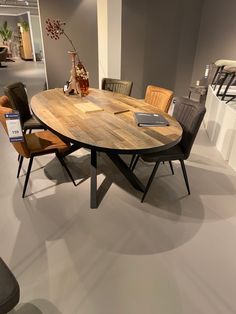 a wooden table with chairs around it in a room filled with other furniture and decor