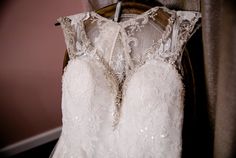 a wedding dress hanging on a hanger