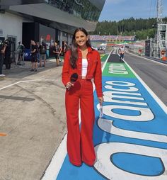 a woman standing on the side of a race track