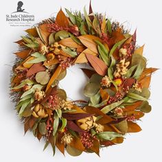 a wreath with leaves and flowers on it