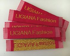 three red and gold name tags on a white surface with the words, liganna fashion