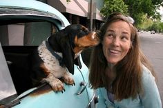 a woman and her dog are sitting in the back of an old blue pickup truck