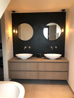 a bathroom with two sinks and mirrors on the wall