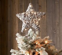 a christmas tree decorated with white and silver ornaments, lights and snowflakes