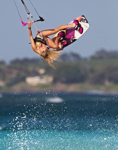 a woman is in the air on a wake board