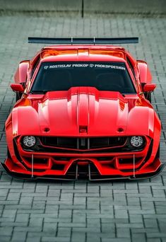 a red sports car parked on top of a brick road