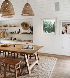 the dining room table is made from wood and has two hanging baskets above it, along with