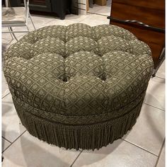 a round ottoman sitting on top of a tiled floor