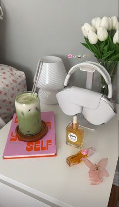 a table with a candle, perfume and flowers on it