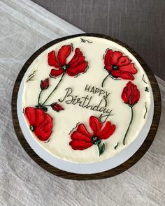 a birthday cake with red flowers on it