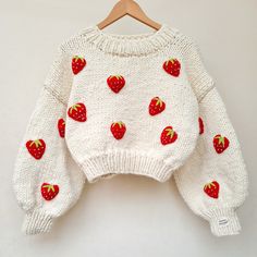 a white sweater with red strawberries on it