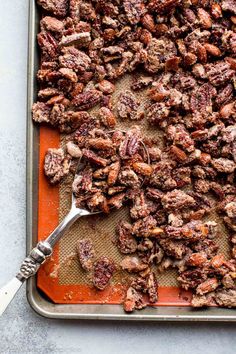 a tray filled with chopped pecans next to a spoon