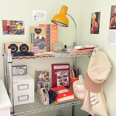 a shelf filled with books and pictures next to a lamp