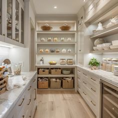 a kitchen filled with lots of white cabinets and counter top space next to wooden flooring