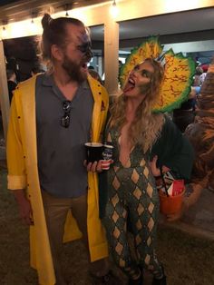 a man and woman dressed in costumes standing next to each other at an outdoor event