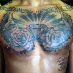 a man with tattoos on his chest and back is holding a diamond in front of him