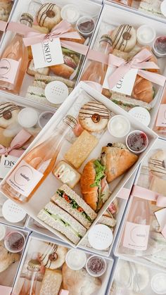 several trays filled with different types of sandwiches and pastries in plastic containers next to each other