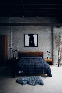 a bedroom with brick walls and exposed ceilings