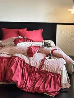 an unmade bed with pink and white sheets