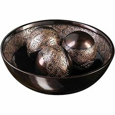 a bowl filled with silver balls on top of a table