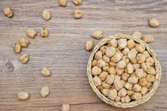 a basket filled with peanuts sitting on top of a wooden table