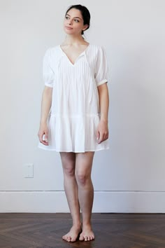 Cotton Voile is a weightless fabric that feels good next to your skin. Move over baggy, shapeless t-shirt that you have been sleeping in, our Pin Tuck Dress is taking your place. The tissue like feel of our 100% cotton is perfect for sleeping in. We have designed it hardware free so no matter how much you toss and turn you will always be comfortable. Available in three slumber ready shades, White, Black and Peony ♦︎ Fabric: 100% Sheer Cotton Voile ♦︎ Pin tucked across chest with simple tie closure ♦︎ Button on sleeve and raw edge on top seam of ruffle skirt Fit Comments ♦︎Fits true to size ♦︎ Cut to be full. Size down for more fitted look ♦︎ Model is size 4 and wearing a small Care instructions ♦︎Machine wash gentle cycle or hand wash ♦︎Do not bleach ♦︎Dry flat ♦︎Cool iron or use steamer White Relaxed Fit Dress With Puff Sleeves, White Billowy Short Sleeve Dress, White Relaxed Fit Sleep Dress, Peony Fabric, Tuck Dress, Chest Opening, British Indian, Cotton Voile, Pin Tucks