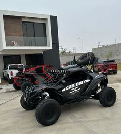 the can - am spyder is parked in front of a building with other vehicles