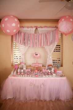 a pink and white dessert table with balloons