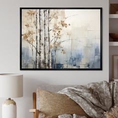 a painting hanging on the wall above a couch in a living room with a lamp