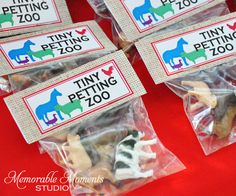 tiny petting zoo treats in plastic bags on a red tablecloth with name tags