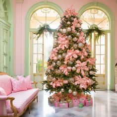 a pink christmas tree in the middle of a living room with lots of presents under it