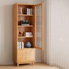 a wooden book shelf with books and other items on it next to a white curtain