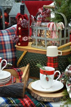 a christmas table setting with red and green plaid napkins, coffee cup, candy canes, mug