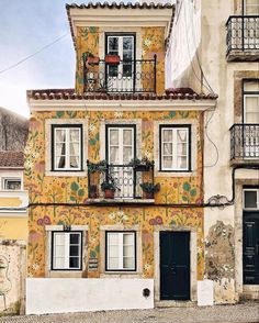 an old building with flowers painted on it's side and balconies above the windows