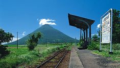 a train station with a mountain in the background