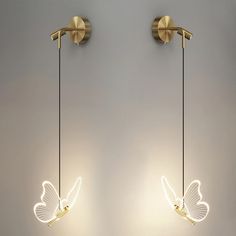 two lights that are on the side of a wall next to each other, one with a butterfly